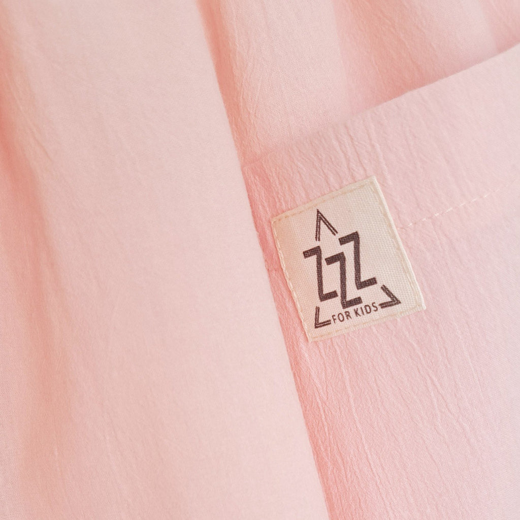 6. Close-up of Zezuzulla logo on peach cotton fabric of kids dress
