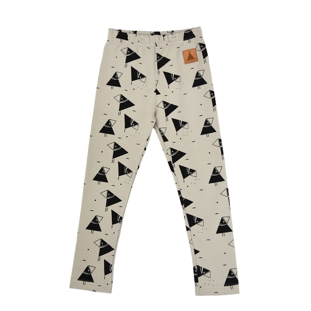 4. Flat lay of kids' beige leggings with black bird print and elastic waistband, featuring Zezuzulla brand patch, made from OEKO-TEX cotton and elastane blend