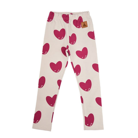 2. Kids' leggings with pink heart pattern on cream background, featuring elastic waistband and Zezuzulla logo patch, shown in studio setting