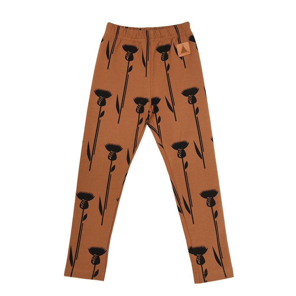 2. Kids' brown leggings with black thistle print, elastic waistband, made from OEKO-TEX cotton and elastane, shown in studio setting