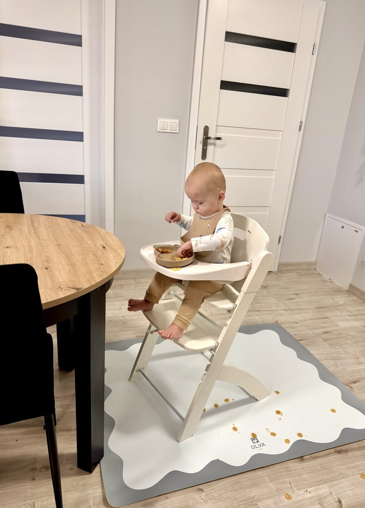 1. Baby in high chair on OLYA KIDS blue frame floor mat during mealtime, modern dining room setting