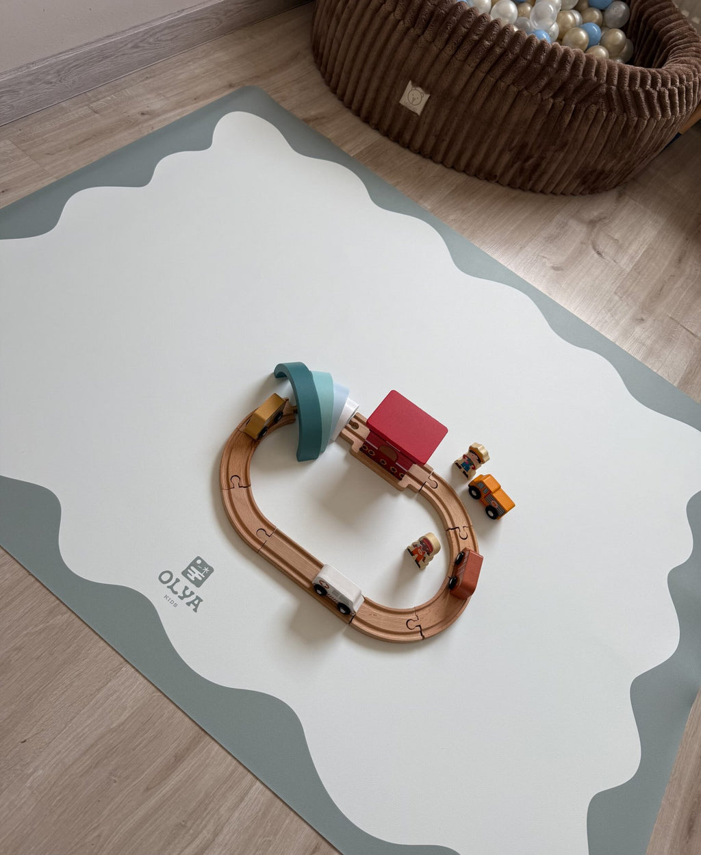 1. Kids' playroom with OLYA KIDS blue frame floor mat featuring toy train set, soft lighting, and wooden floor