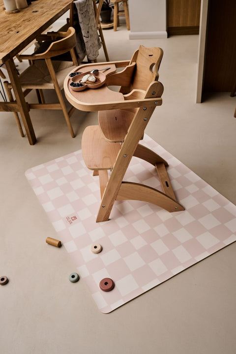 1. Wooden high chair on pink and beige checkered OLYA KIDS floor mat in dining room setting