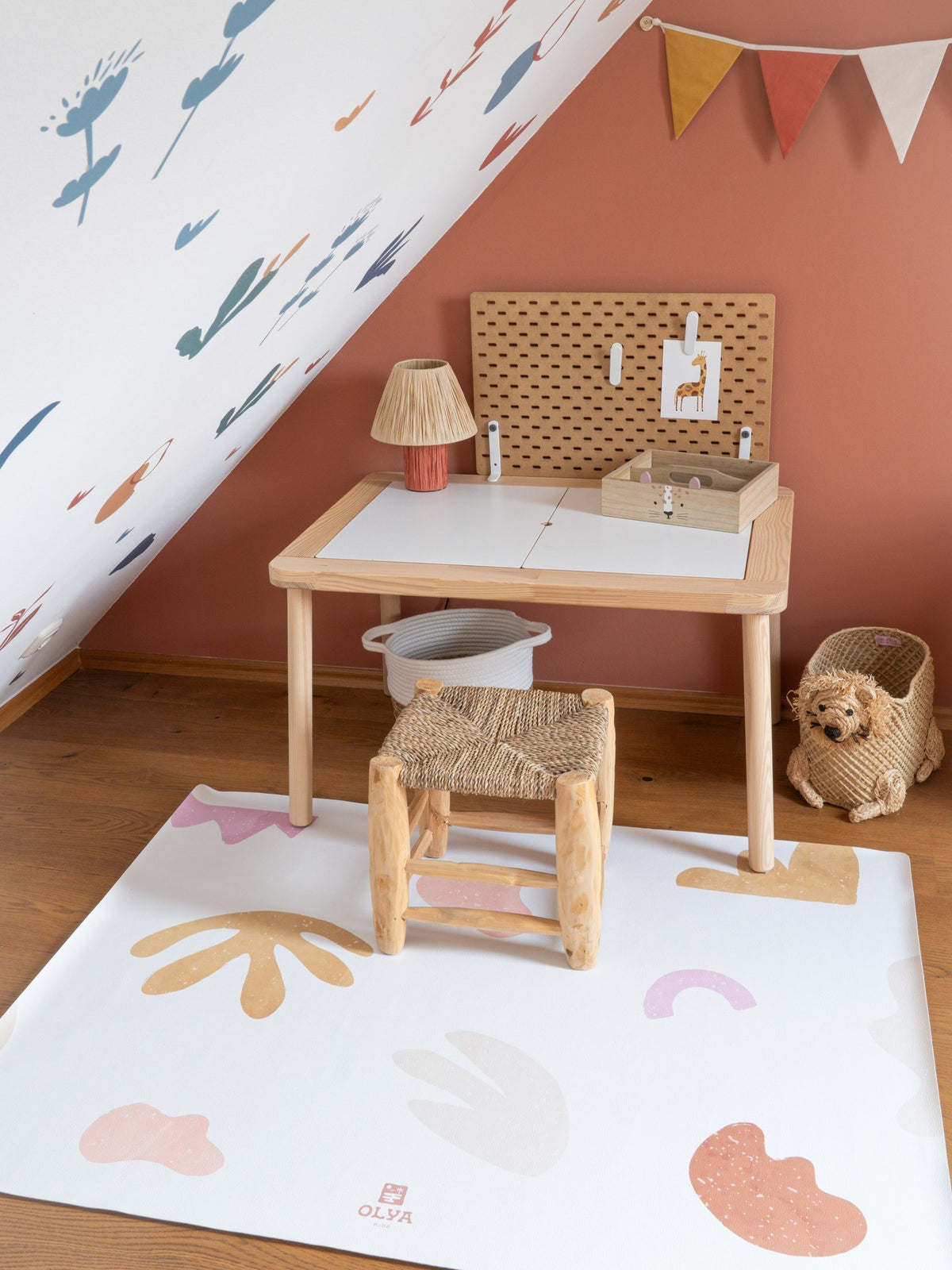 3. OLYA KIDS non-slip waterproof floor mat in kids' playroom under wooden table and chair, featuring pastel abstract designs on wooden floor