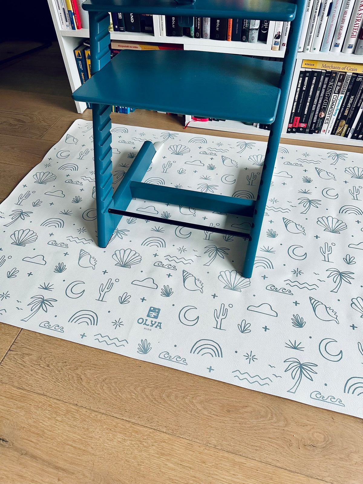 1. Blue high chair on OLYA KIDS Palm Beach Azure floor mat with beach-themed patterns
