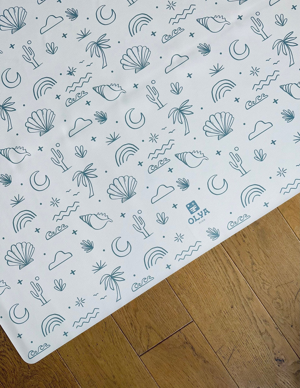 2. OLYA KIDS Palm Beach Azure floor mat with playful beach-themed patterns on wooden floor