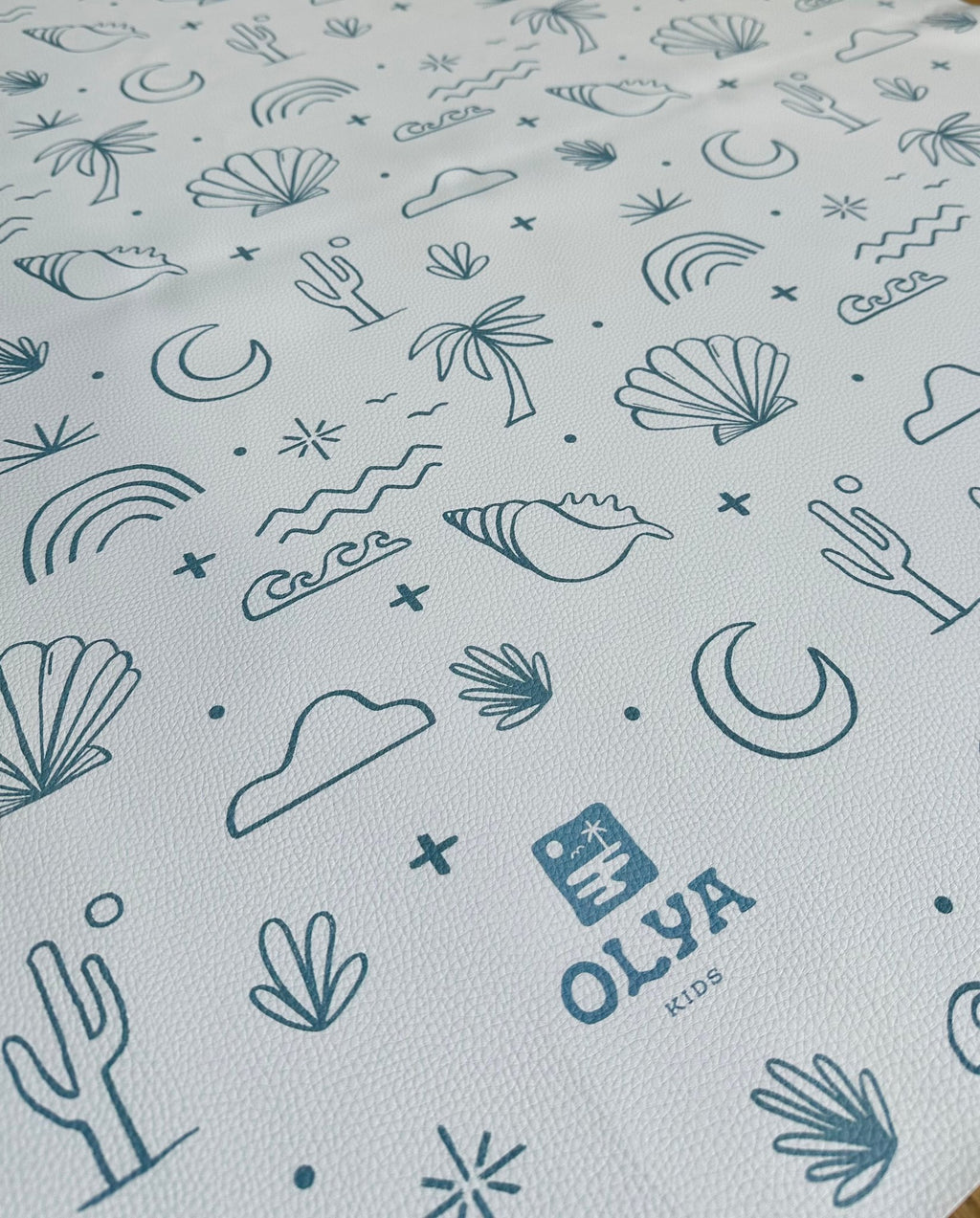 3. Close-up of OLYA KIDS floor mat showing palm trees, shells, and waves pattern