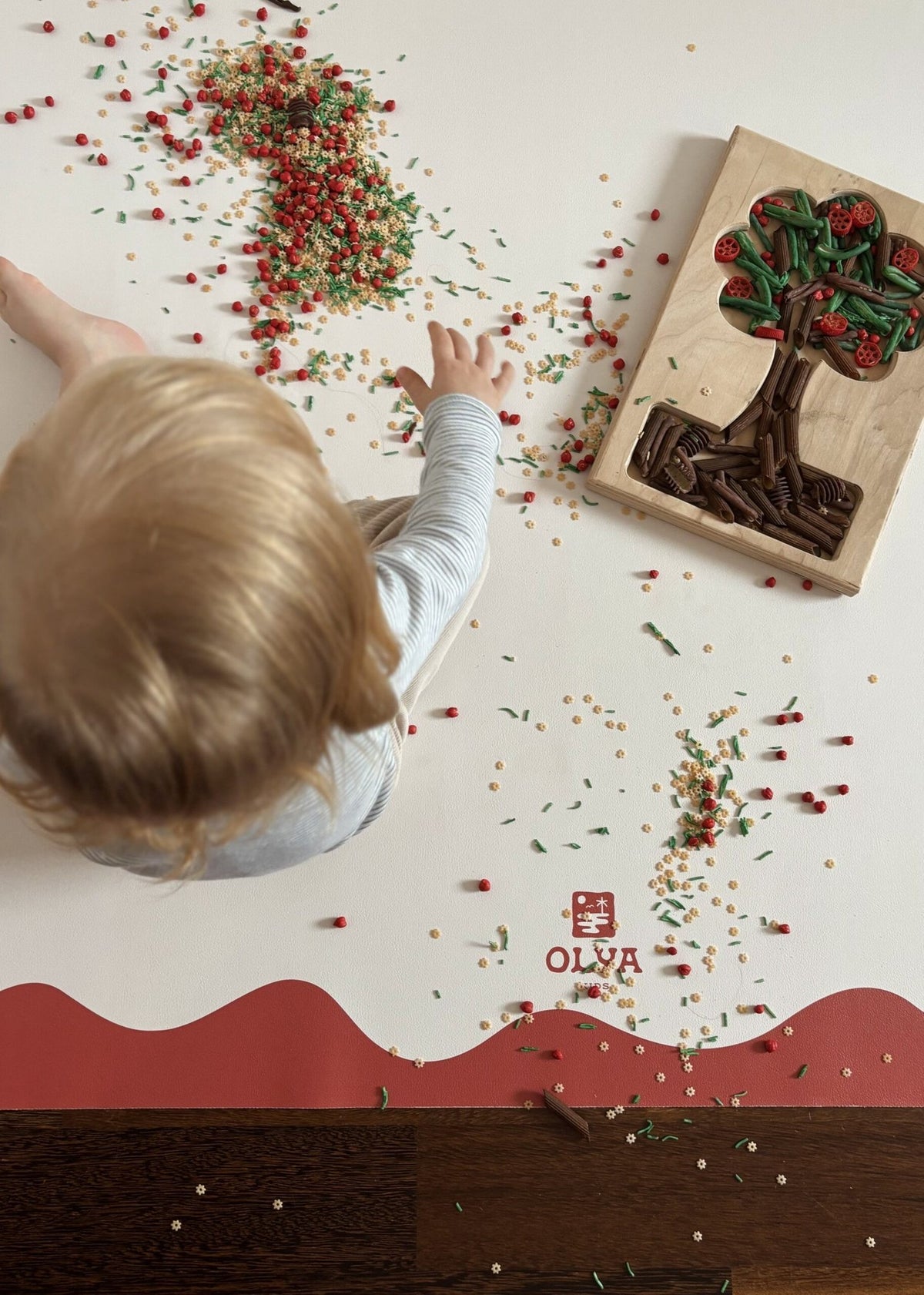 2. Child playing with food on OLYA KIDS red-framed vegan leather floor mat showing non-slip feature