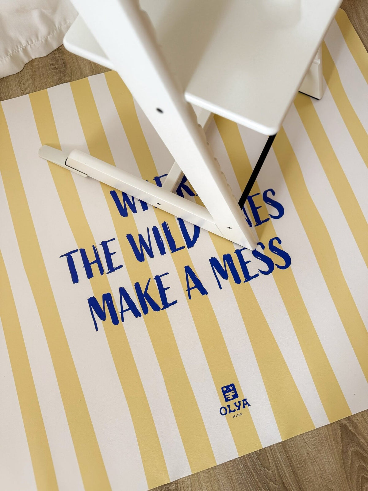 3. White high chair on yellow and white striped floor mat with text 'Where the wild ones make a mess', OLYA KIDS logo visible