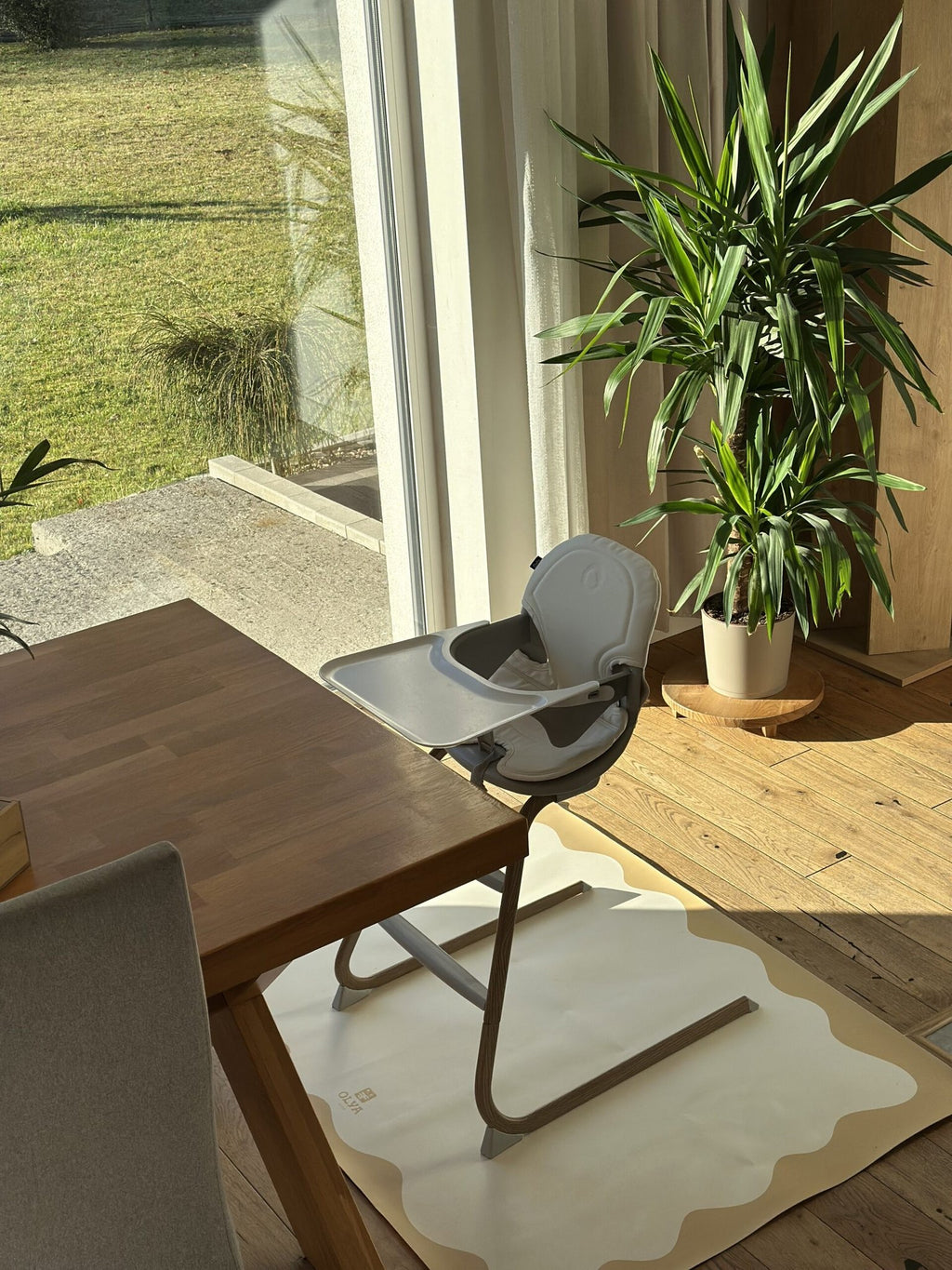4. High chair on OLYA KIDS yellow-framed floor mat in a sunlit dining area with wooden flooring