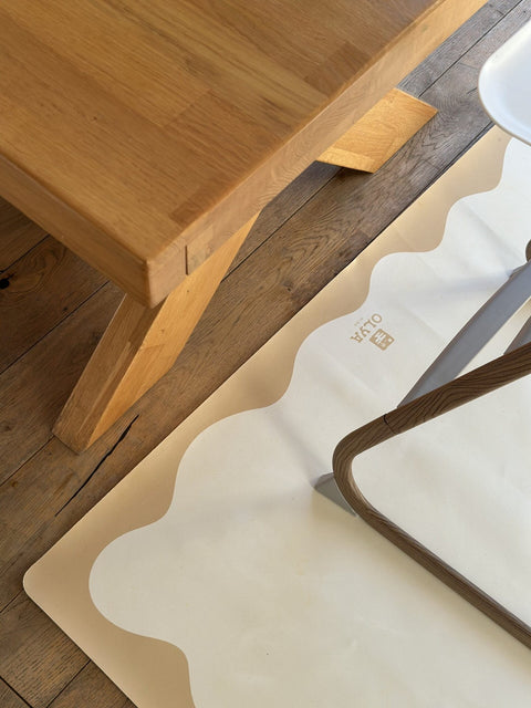 2. OLYA KIDS yellow-framed floor mat under a wooden table and high chair, showing non-slip vegan leather texture