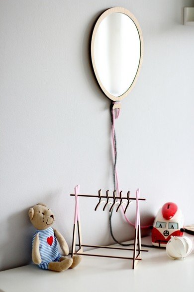 3. Balloon-shaped mirror on wall above white cabinet with teddy bear, toy car, and miniature clothes rack in kids room