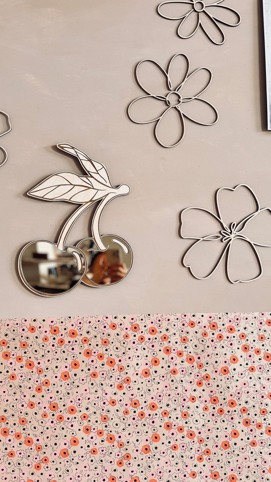 2. Child-friendly cherry mirror with shatterproof acrylic reflecting room interior, surrounded by floral wall decor