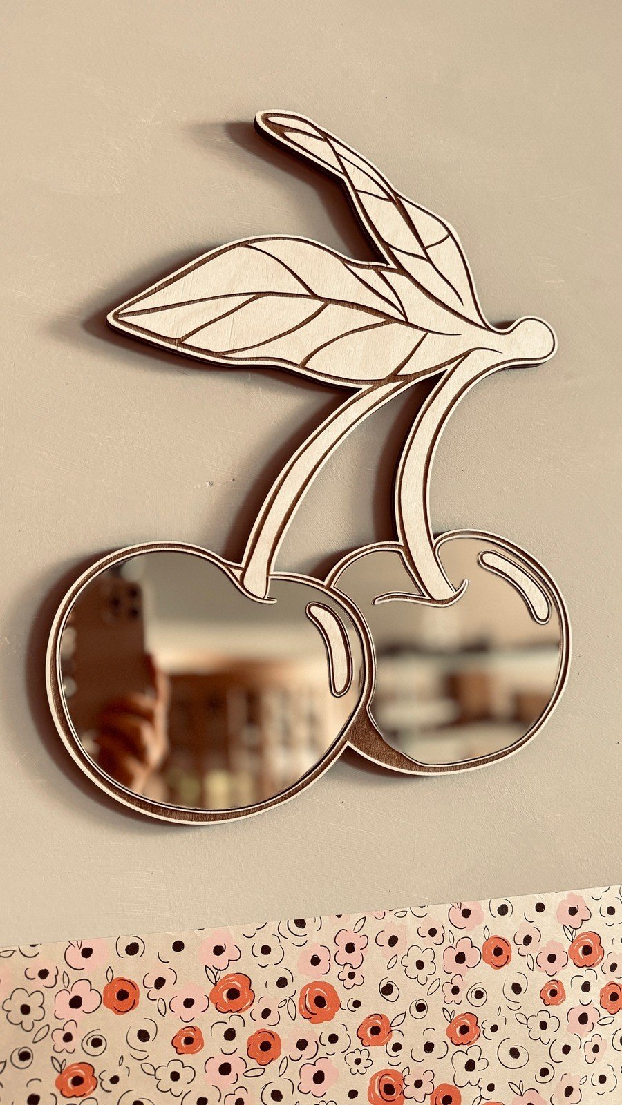 4. Cherry mirror with gold-tinted acrylic reflecting room, natural plywood frame, floral wall pattern