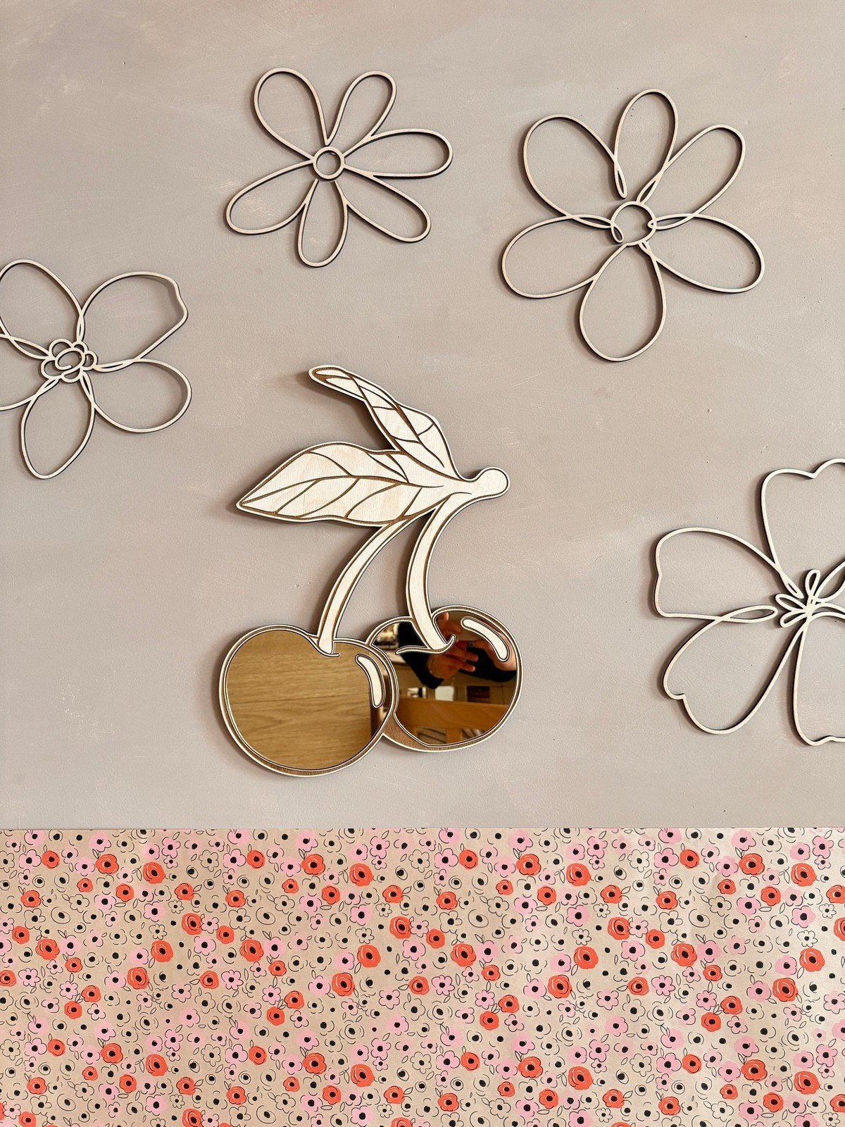 1. Cherry-shaped mirror with gold-tinted acrylic and natural plywood frame on a wall with floral decorations