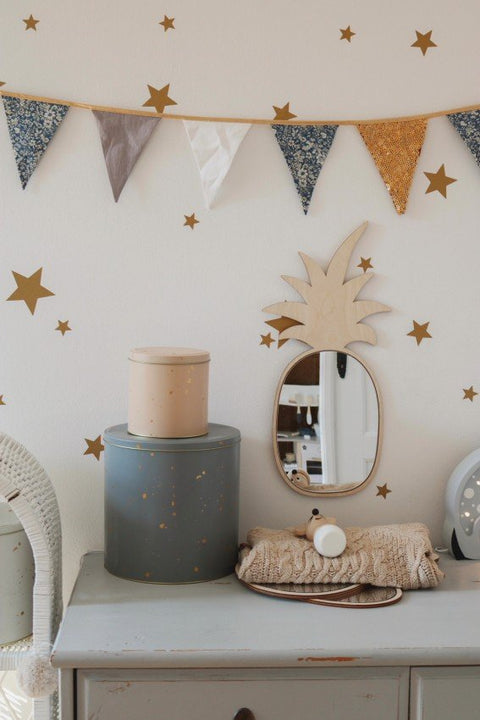 1. Pineapple-shaped mirror with natural plywood frame on nursery dresser with star wall decals and bunting