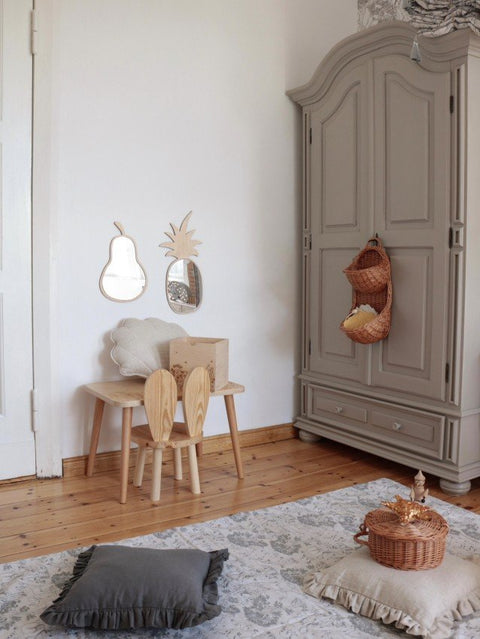 2. Pineapple-shaped mirror with natural plywood frame on wall above children's table in playroom