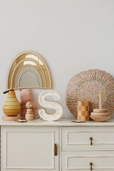 4. Rainbow mirror with gold-tinted acrylic and plywood frame on nursery shelf with toys and floral cushion