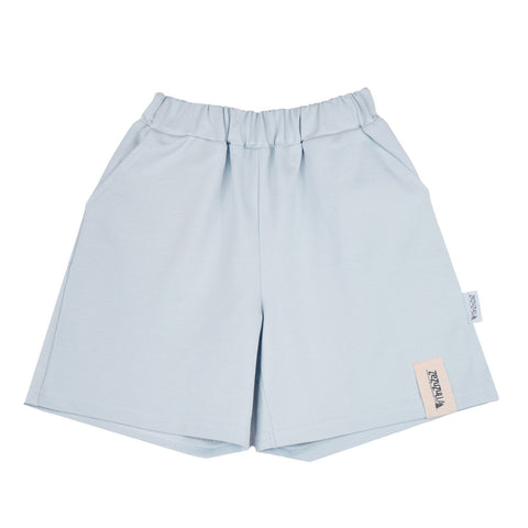 2. Flat lay of kids' pastel blue cotton shorts with elastic waistband and Zezuzulla logo tag