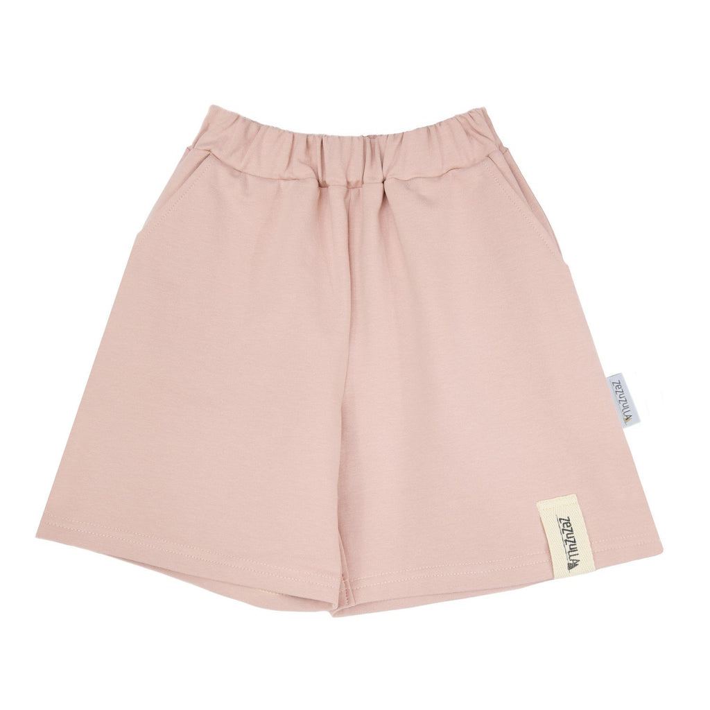 2. Studio shot of pastel pink kids shorts with elastic waistband and Zezuzulla logo tag on clean white background