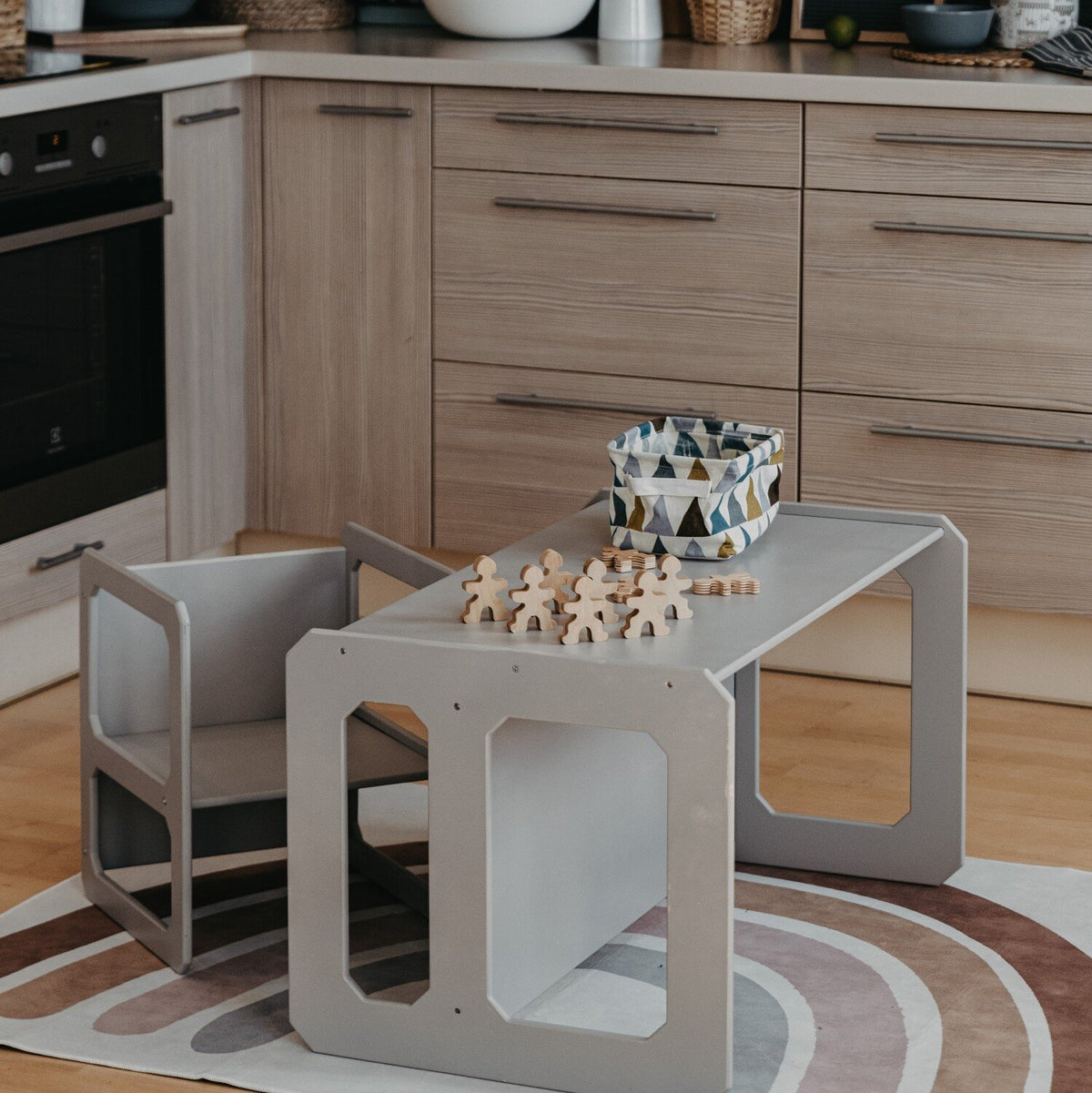 17. Grey Montessori table and chair set in a kitchen with a chess set on top