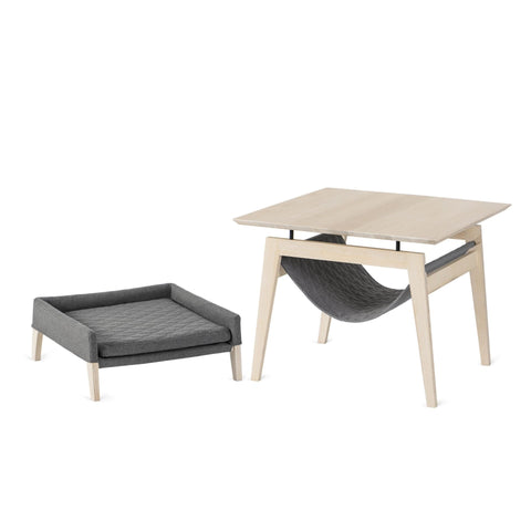 1. Light grey Kikko table and Lulu bed for cats by Labbvenn, featuring modern design with ash wood and quilted fabric, shown in a studio setting.