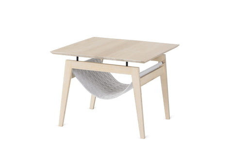 2. Light grey Kikko table by Labbvenn featuring minimalist Scandinavian design with a quilted fabric hammock for cats, shown in a studio setting highlighting its dual functionality as a coffee table and pet resting spot.