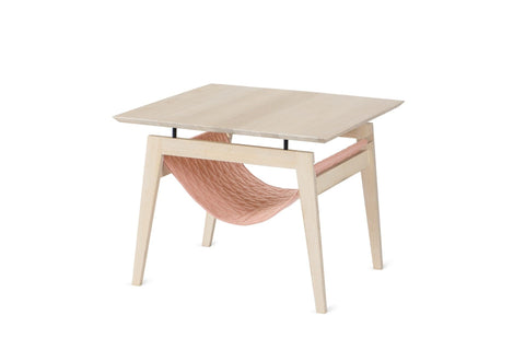 2. Scandinavian-style Kikko table by Labbvenn with light wood finish and raspberry quilted fabric hammock for cats, featuring minimalist design and metal elements, shown in studio setting.