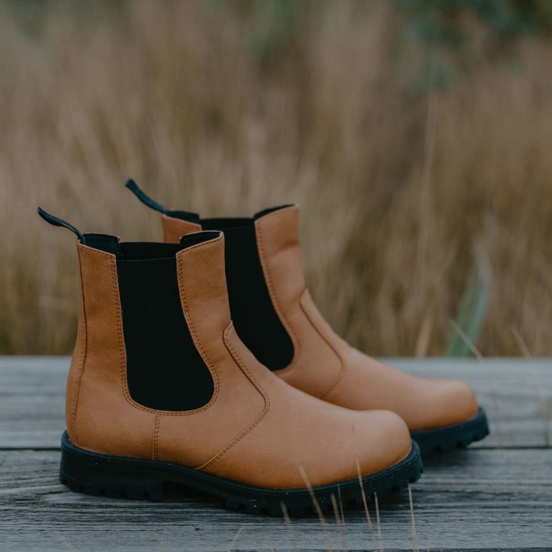 6. Pair of KIRA 3.0 Chelsea Boots in brown, side view on wooden surface