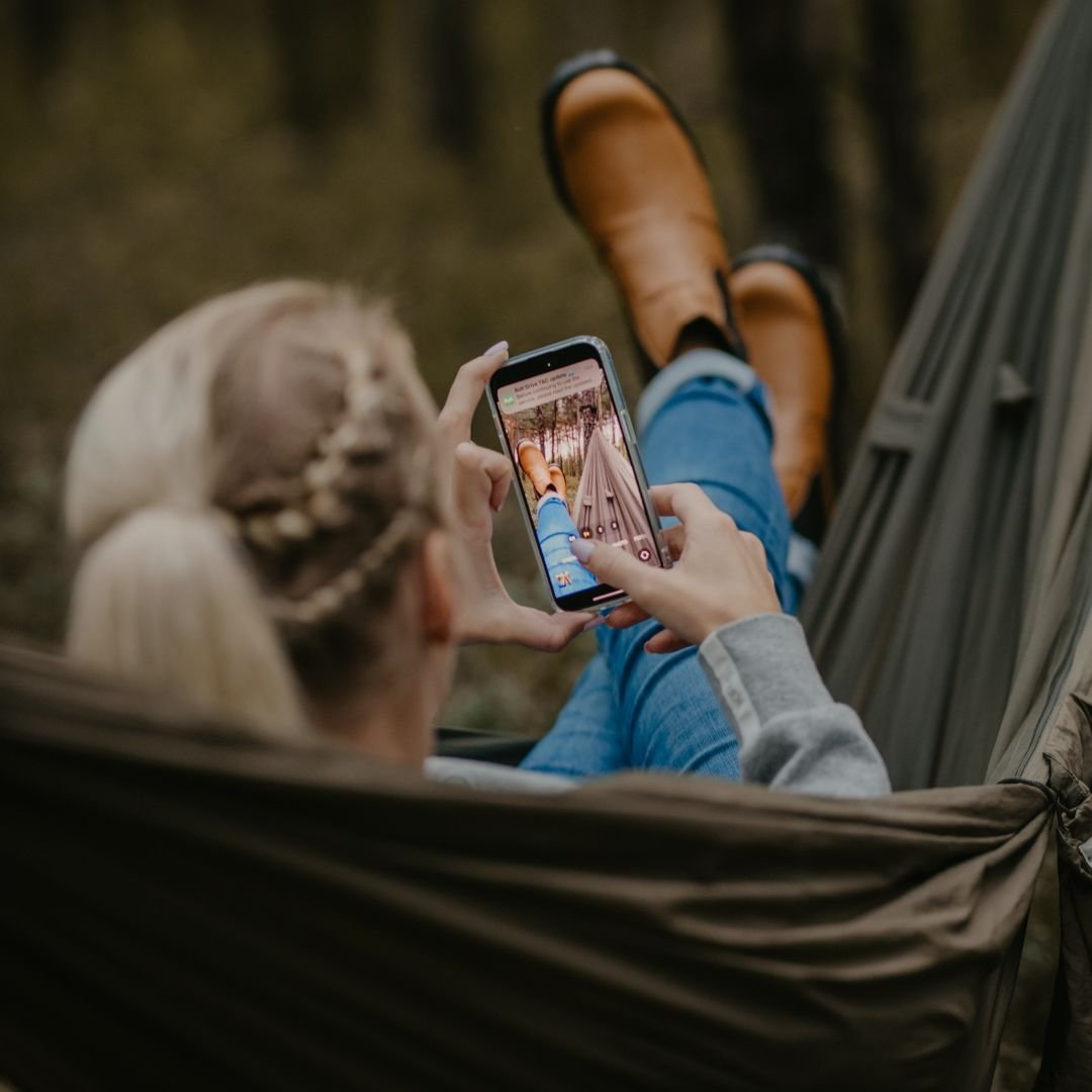 1. Woman relaxing in hammock wearing KIRA 3.0 Chelsea Boots in brown, showcasing eco-friendly style