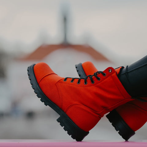 1. Lifestyle image of KIRA 5.0 red boots worn by a person, showcasing sustainable style and deep tread sole