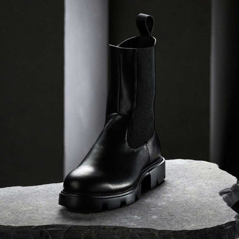 3. Black KIRA Chelsea Rebel boot with microfiber upper and bold sole on stone surface in studio lighting