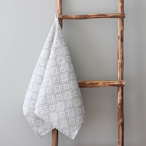 1. LOKO kitchen towel with Setumaa folk art pattern in grey and white, hanging on rustic wooden ladder, made of 52% linen and 48% cotton, designed in Estonia