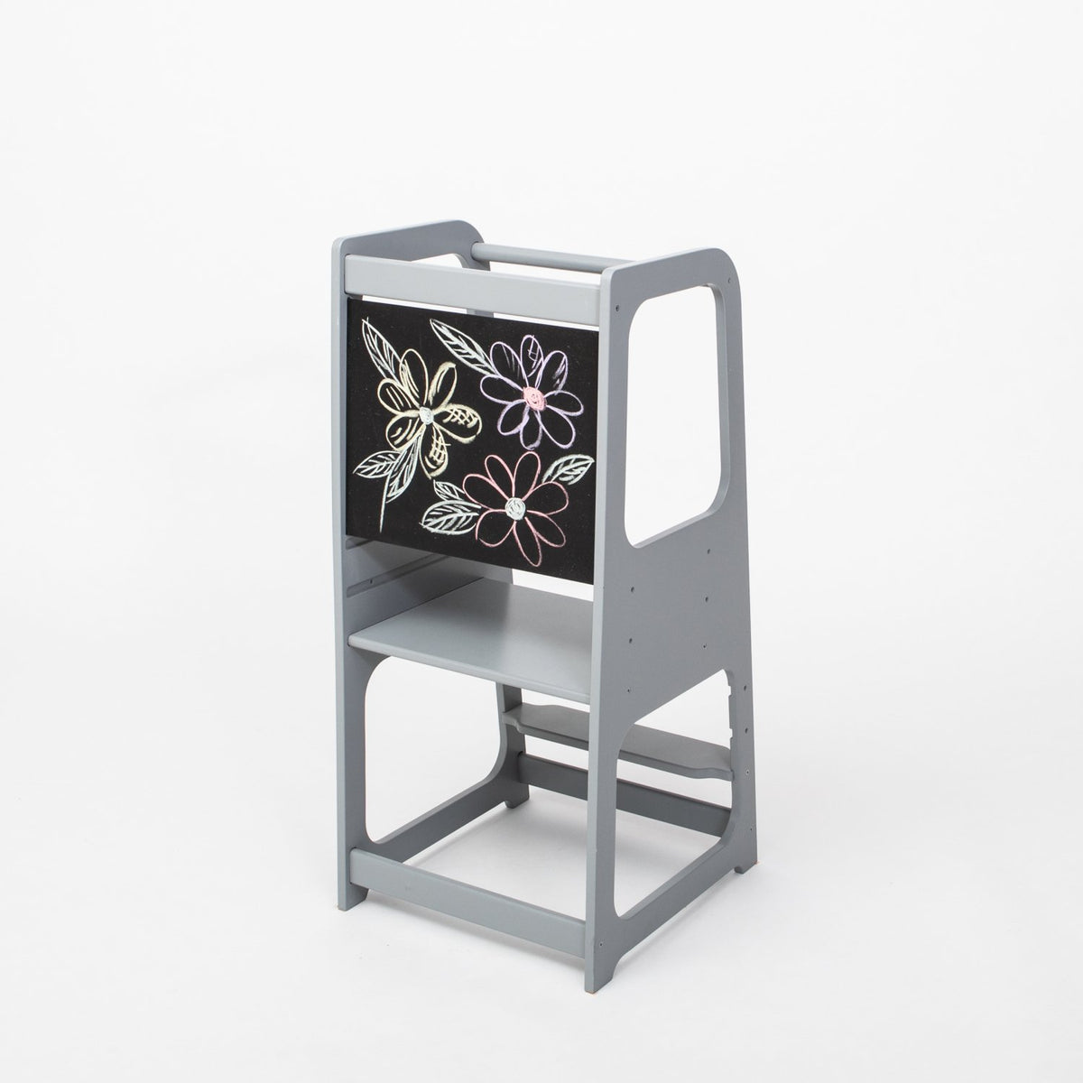 2. Grey Montessori kitchen helper tower with blackboard panel featuring floral drawing, shown in a studio setting