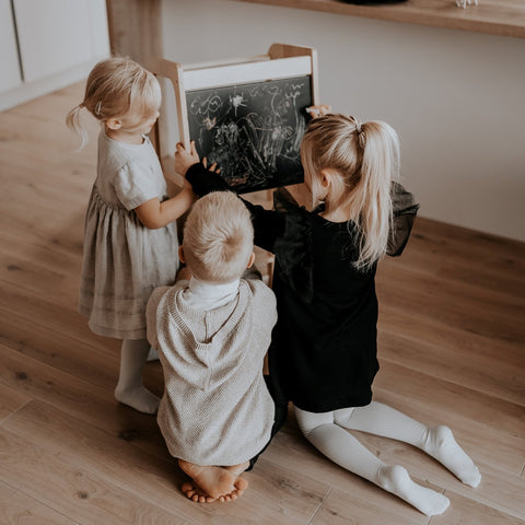 1. Three children drawing on blackboard of natural wood Montessori kitchen helper tower