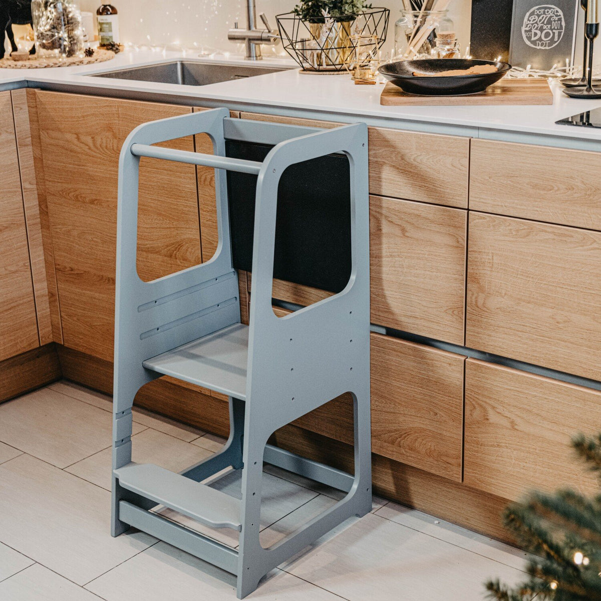 2. Grey Montessori kitchen helper tower in modern kitchen setting with holiday decor