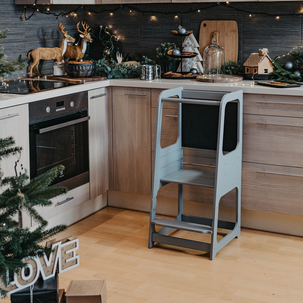 2. Grey Montessori kitchen helper tower in modern kitchen with Christmas decorations