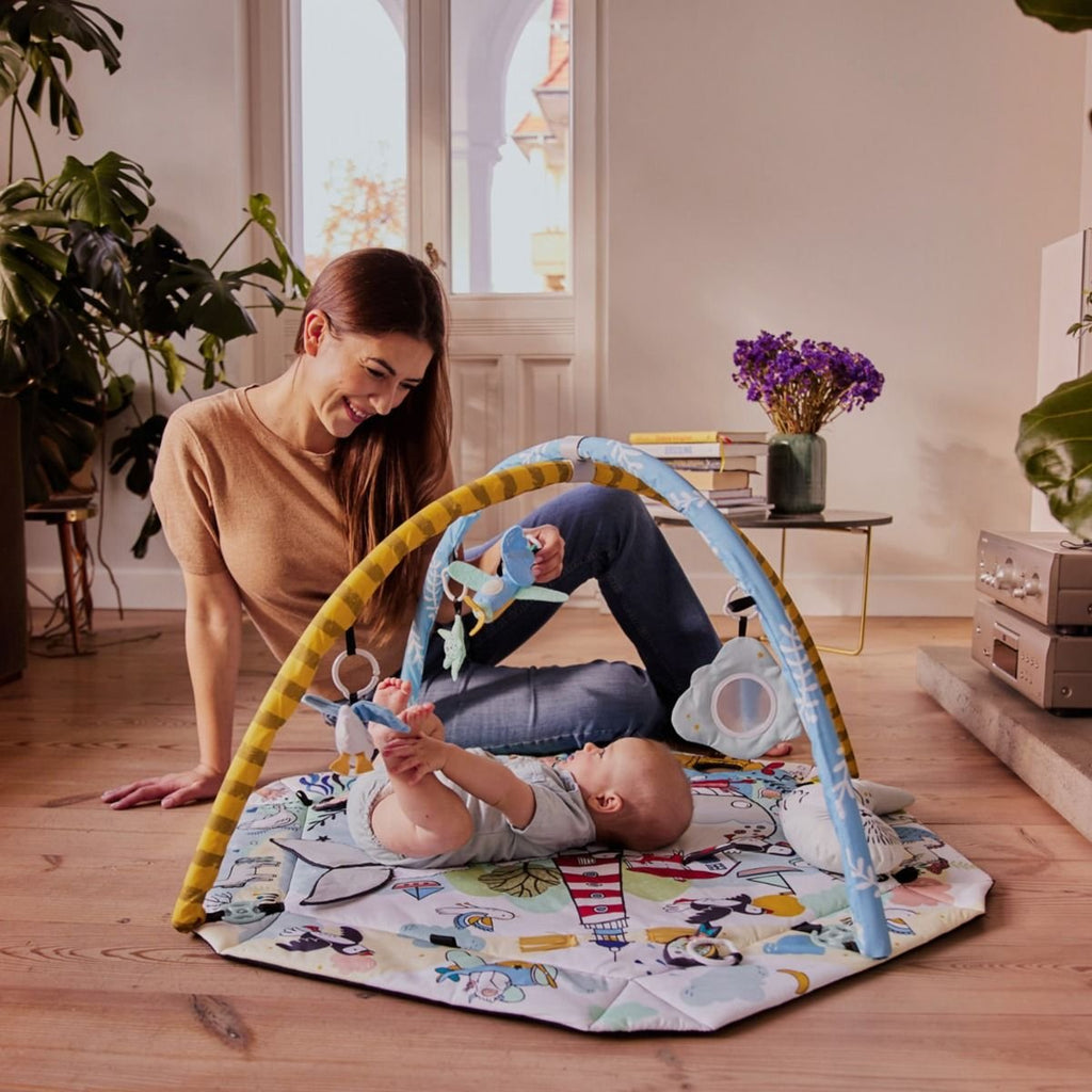 4. Woman smiling at baby playing on Kinderkraft Smartplay Sea playmat in cozy living room