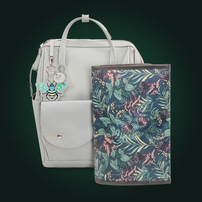 10. Grey Kinderkraft Treasureback backpack with floral changing mat and bee keychain accessory