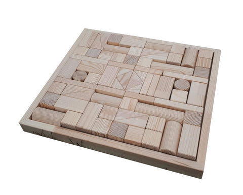 2. Flat lay of hand-made wooden blocks set neatly organized in a wooden tray, highlighting the variety of shapes and pinewood material