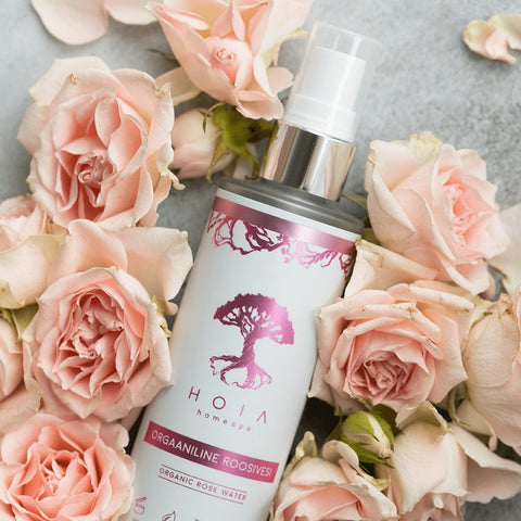 2. HOIA homespa Organic Rose Water 100ML surrounded by soft pink roses