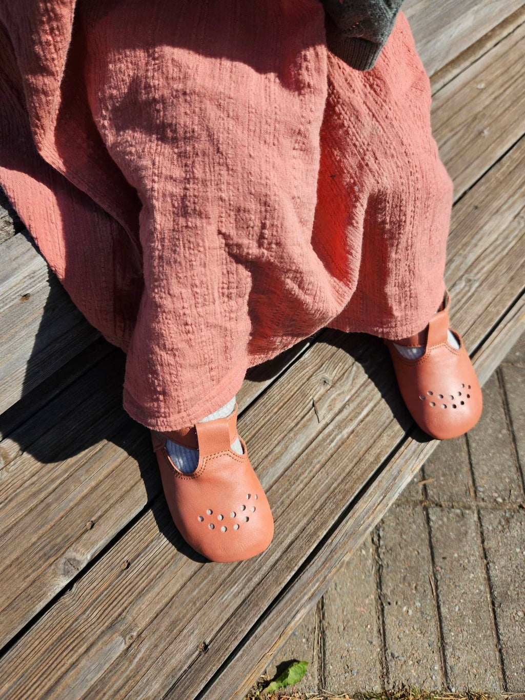 3. Close-up of Omaking Mutsu coral slippers on child's feet, showing perforated design