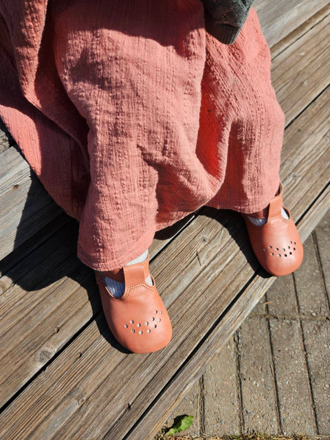 3. Close-up of Omaking Mutsu coral slippers on child's feet, showing perforated design