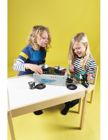 2. Two children playing with a space-themed tea set on a table, featuring cups, plates, and a coffee pot, against a yellow background