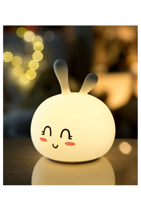 3. Glowing white Bunny Silicone Lamp with smiling face in a dimly lit room