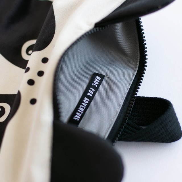 10. Interior view of Muni Panda backpack showing grey lining and 'Made for Adventure' label