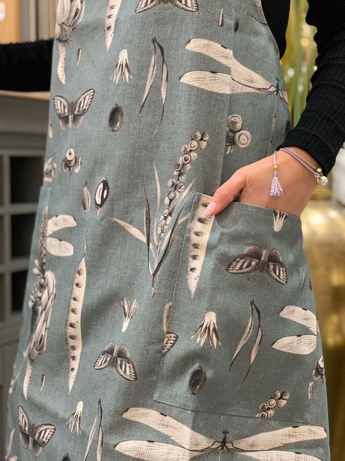 3. Close-up of Seeds Aqua print apron pocket detail, showing botanical design on cotton fabric