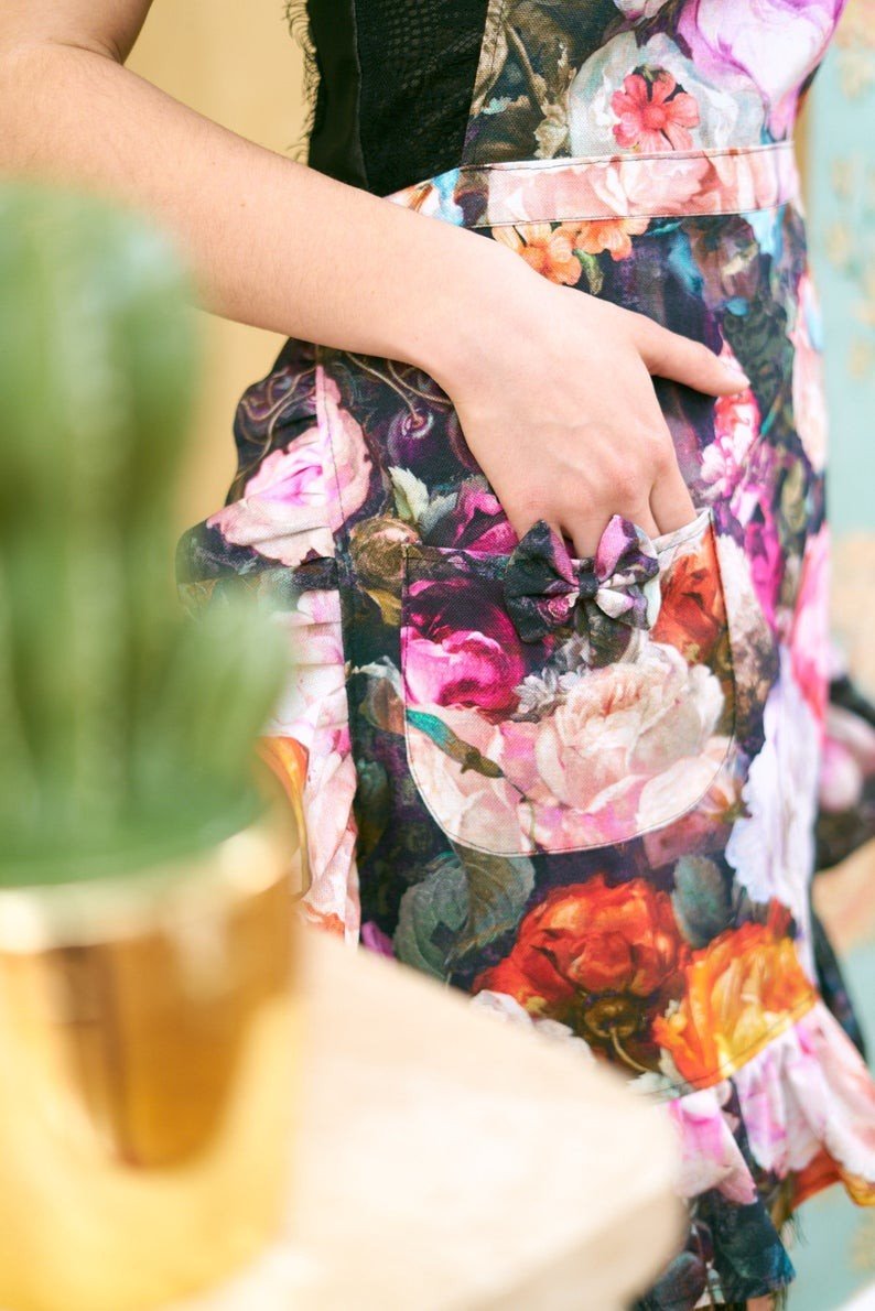 3. Close-up of floral apron pocket with ruffles, highlighting colorful print and bow detail