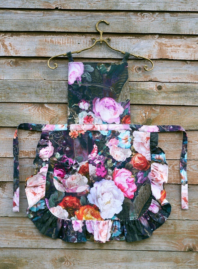 4. Flat lay of floral apron with ruffles on wooden background, showing full design and vibrant colors