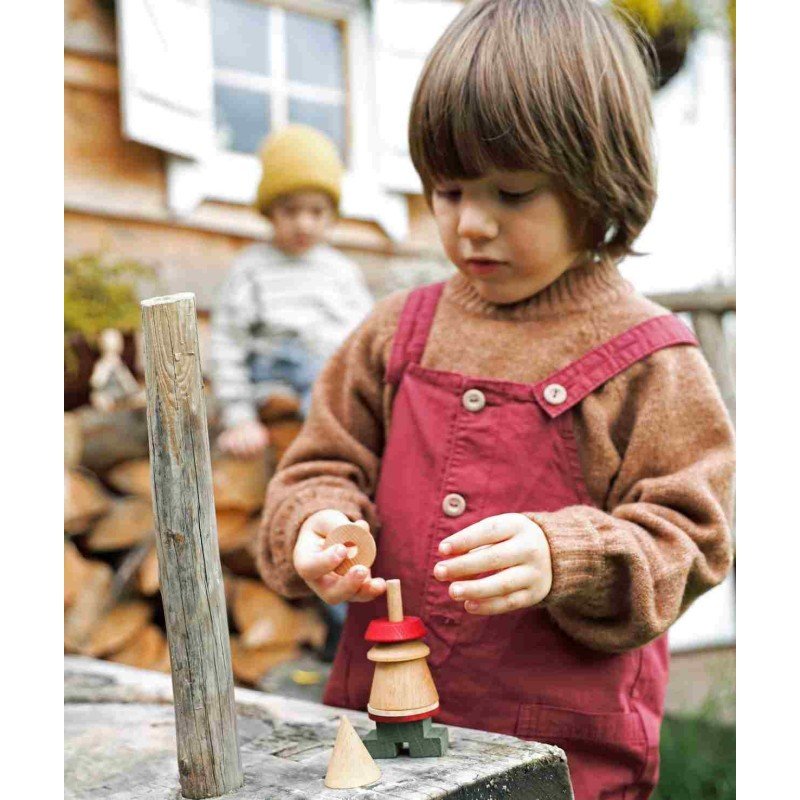 1. Child in brown sweater and maroon overalls assembling LALA Stick Figure Puzzle outdoors